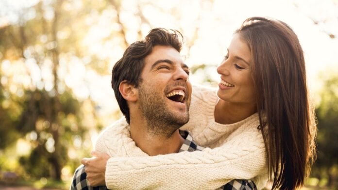 Two people smiling and making eye contact as their brainwaves synchronize in harmony.